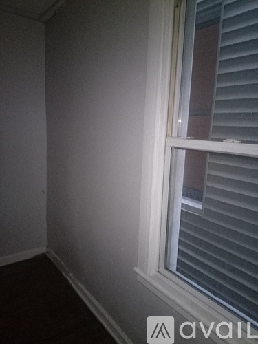 A room with a window and blinds.