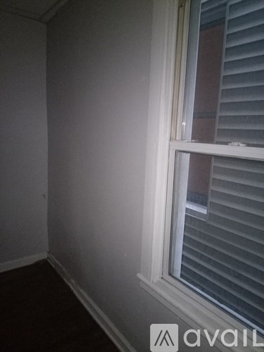 A room with a window and blinds.