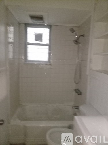 A small bathroom with a toilet, a bathtub and a window.