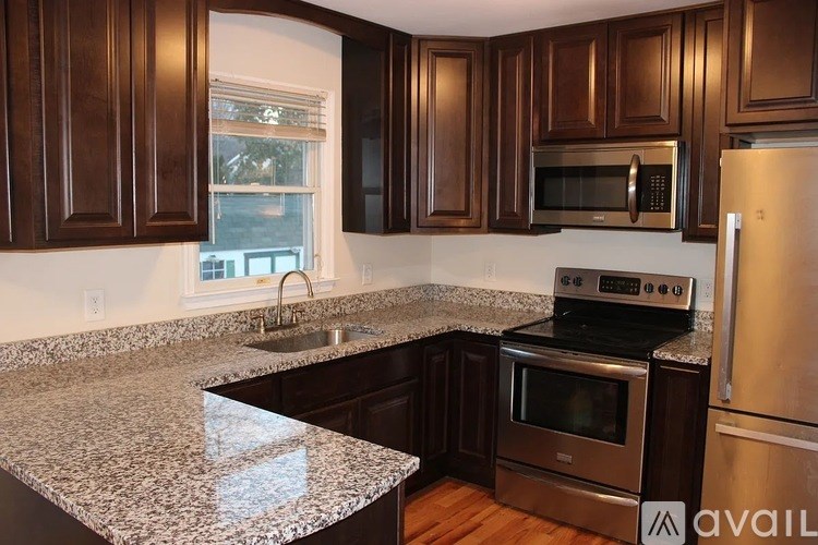 A kitchen with dark brown cabinets and stainless steel appliances.