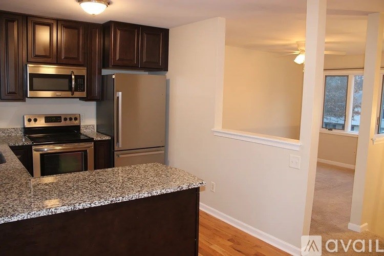 A kitchen with brown cabinets and a granite countertop.