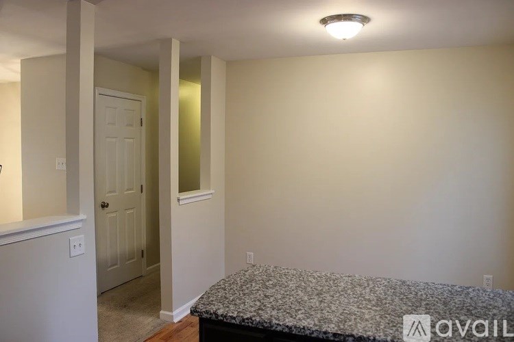 A bedroom with a bed, a door, and a window.