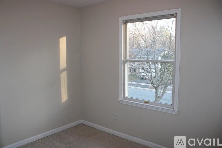 A room with a window showing a tree and a building outside.