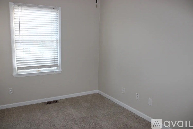 A room with a window and carpeted floor.