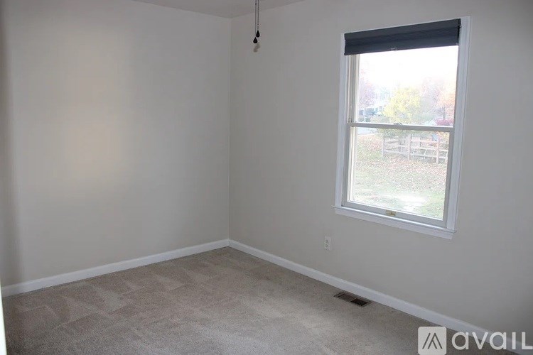 A room with a window and carpeted floor.