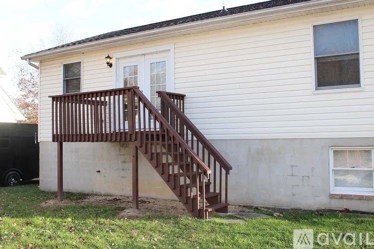 A house with a wooden staircase leading to the front door.
