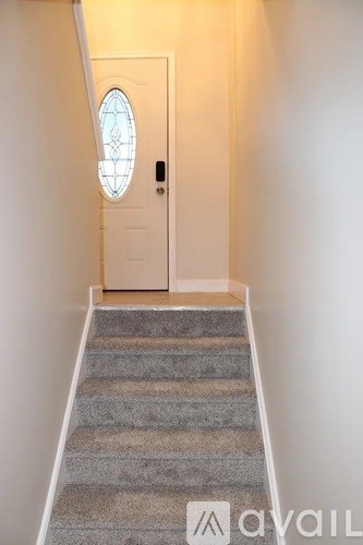 A staircase with a white door at the top.