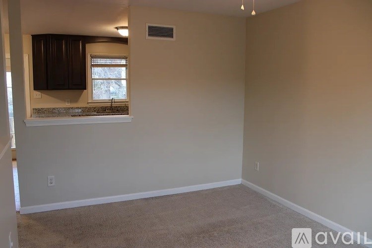 A room with beige walls and carpeted floor is available for rent.
