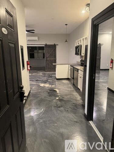 A kitchen with a dark floor and a black door.