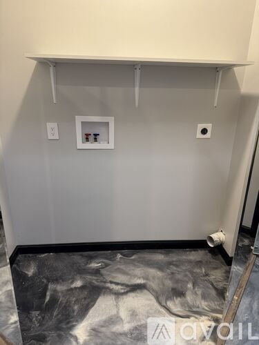 A wall with a shelf and two outlets.