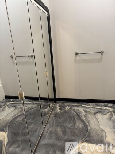 A bathroom with marbled floors and a wall-mounted towel rack.