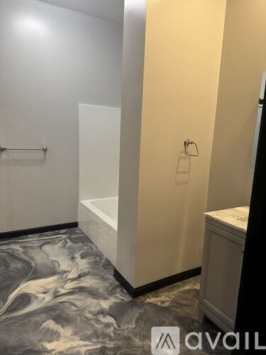 A bathroom with a marble floor and a white shower stall.
