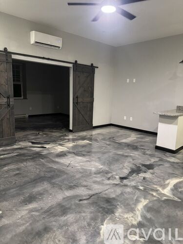 A room with a marble floor and a ceiling fan.