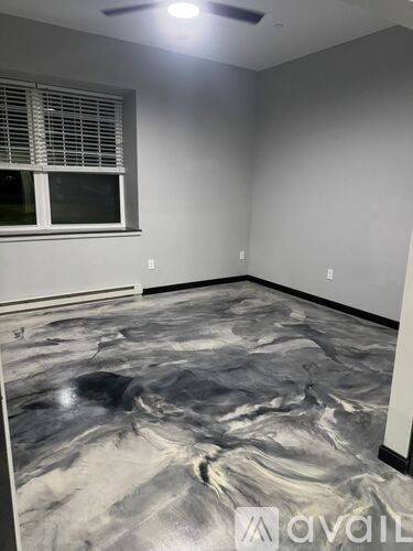 A room with a marble floor and a window with blinds.