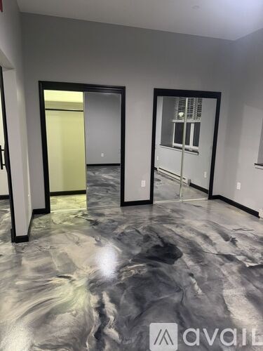 A room with a marble floor and a door leading to another room.