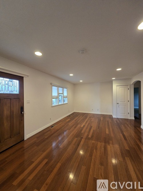 A room with wooden flooring and white walls.