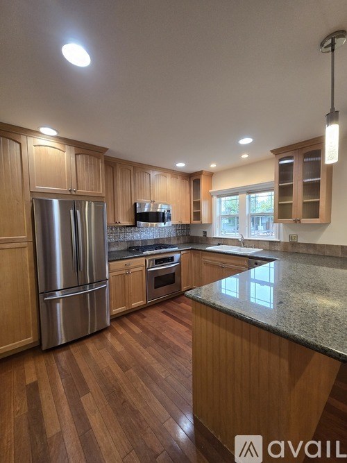 A kitchen with wooden cabinets and a granite countertop.
