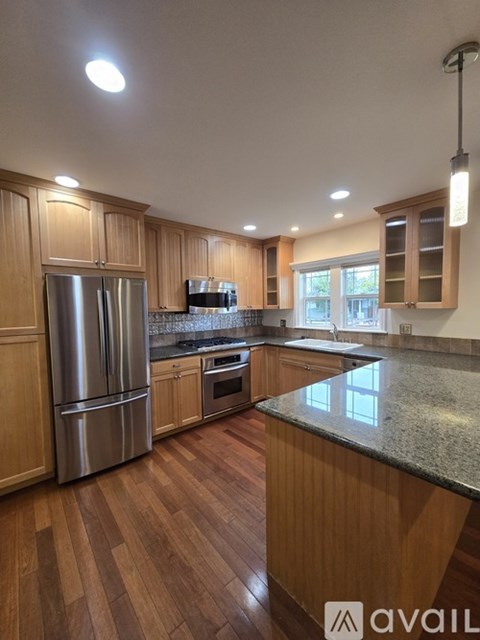 A kitchen with wooden cabinets and a granite countertop.
