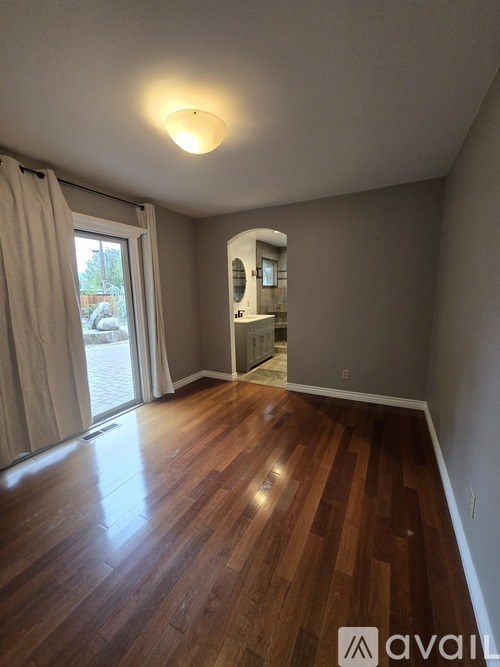 A room with wooden flooring and a sliding glass door.
