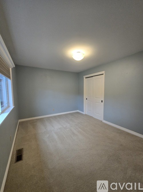 A room with a carpeted floor and a door.