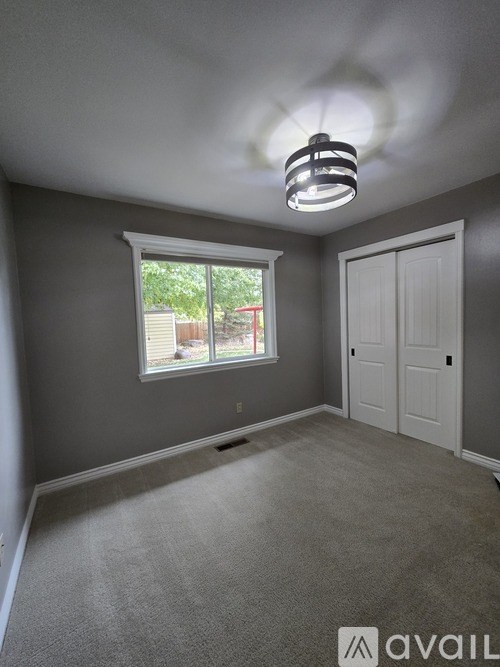 A room with a window and a door is available for rent.