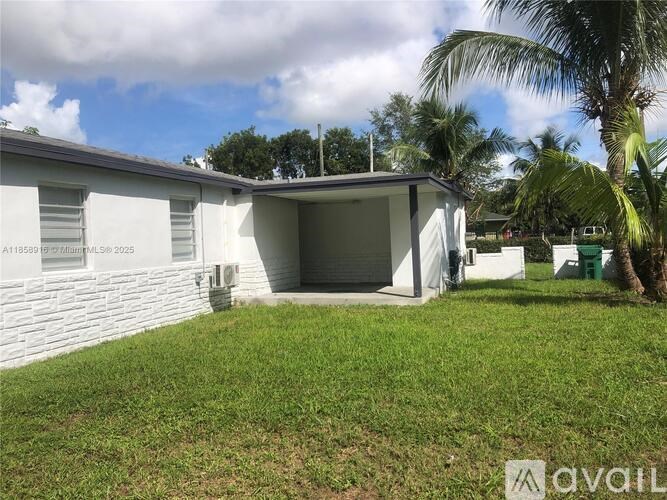 A white house with a garage and a green lawn.