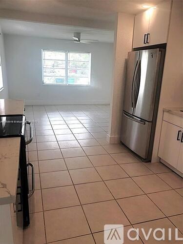 A kitchen with a refrigerator, stove, and sink.