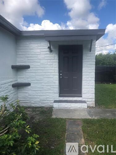 A small white house with a dark brown door.