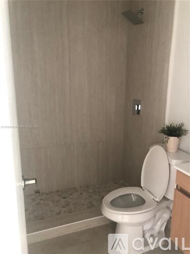 A white toilet with the seat up in a bathroom.