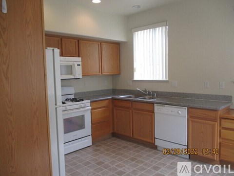 A kitchen with wooden cabinets and white appliances.