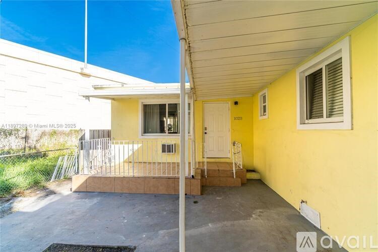 A yellow house with a white door and windows.
