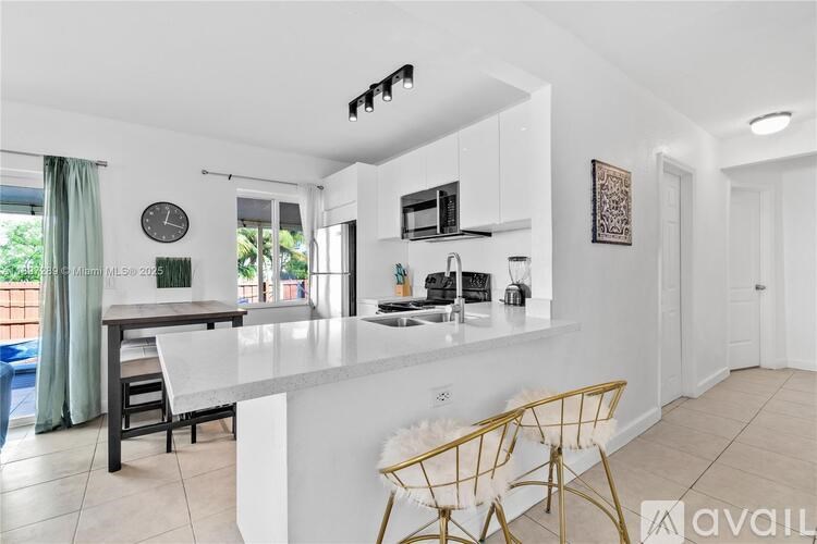 A kitchen with white countertops and a dining table with chairs.
