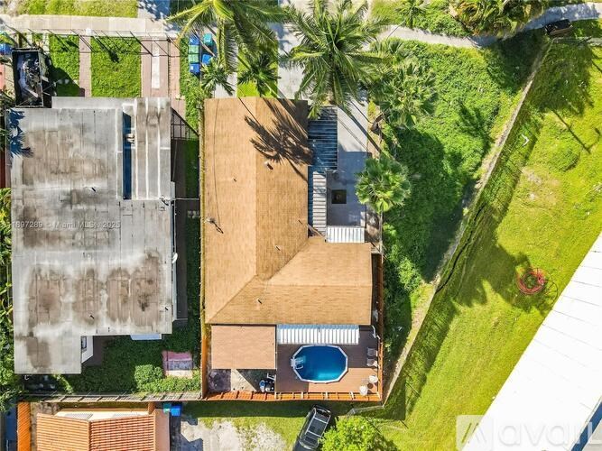 A house with a pool surrounded by a green lawn.