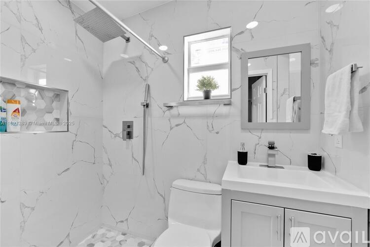 A bathroom with marble walls and a white sink.