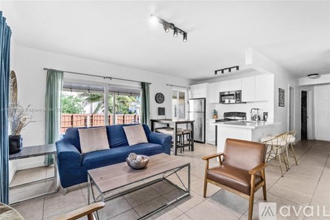 A living room with a blue couch and a brown chair.