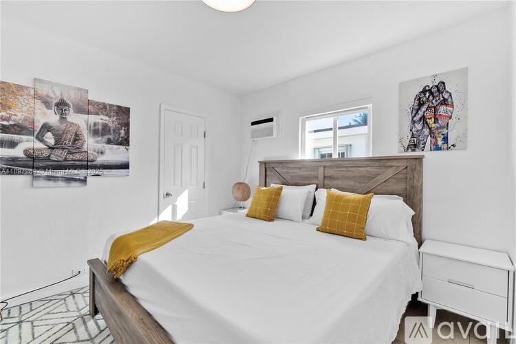 A bedroom with a bed, a window, and two pictures on the wall.