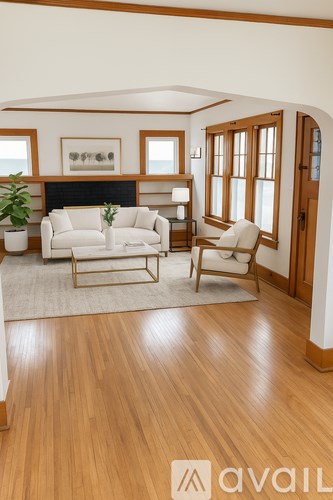 A living room with a white couch and a wooden floor.