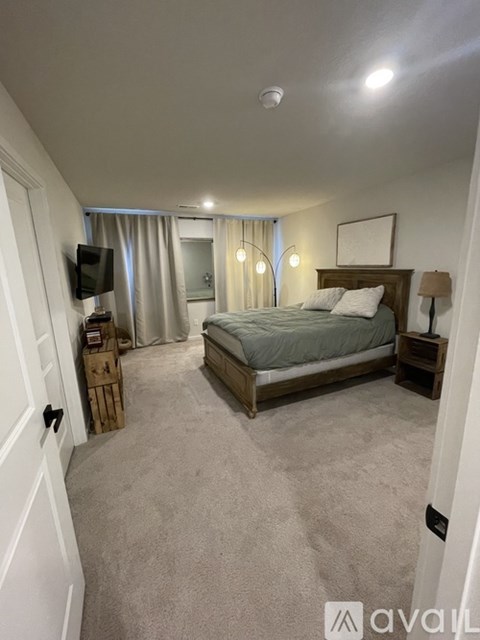 A bedroom with a large bed and a flat screen TV mounted on the wall.