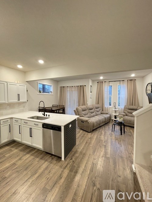 A modern kitchen with a dining area and a living room.