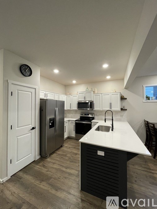 A modern kitchen with a large island and stainless steel appliances.