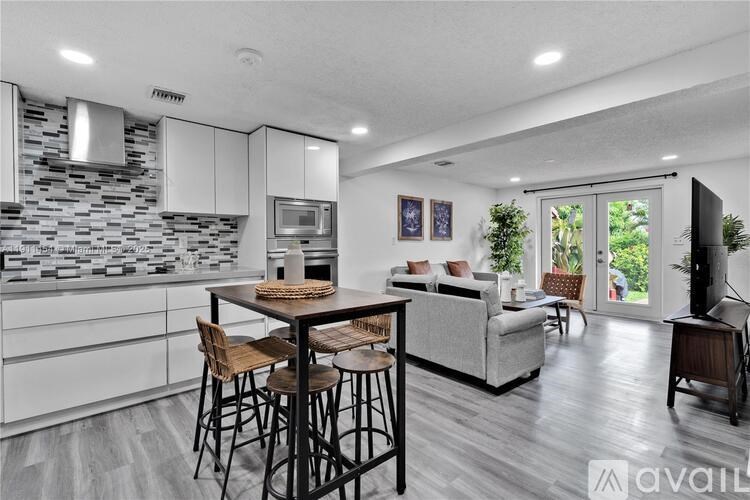 A modern kitchen with a bar area and a dining table set up.