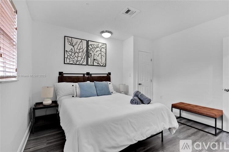 A bedroom with a large bed and a bench.