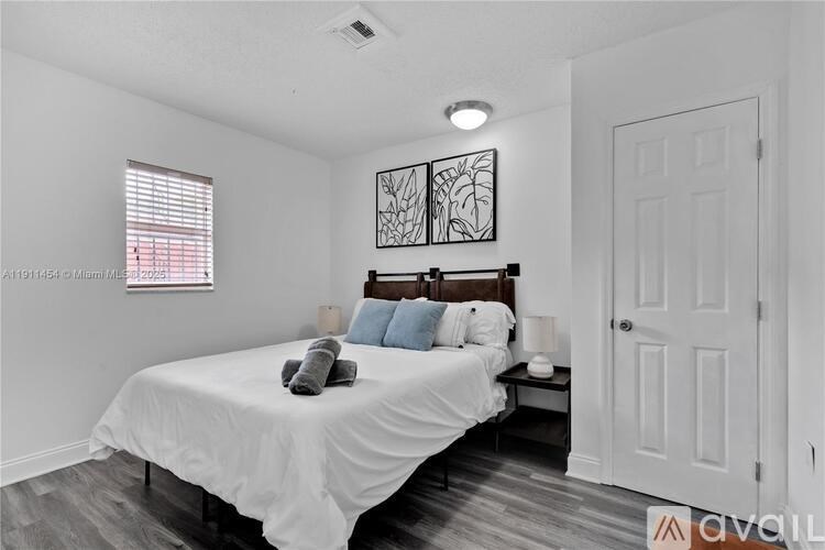 A bedroom with a bed, pillows, and a wall art.