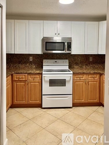 A kitchen with a white oven and microwave above a stove.