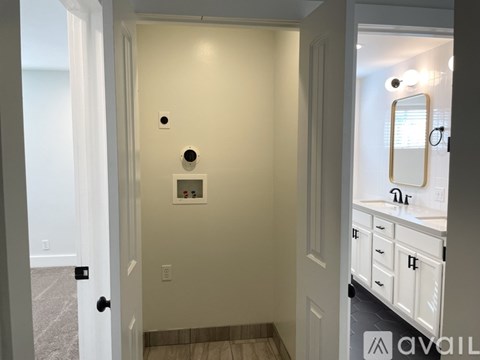 A white door with a black handle and a round black object on the wall.