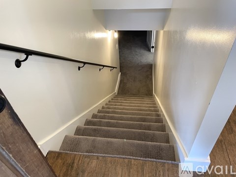 A staircase with a metal handrail and wooden steps.