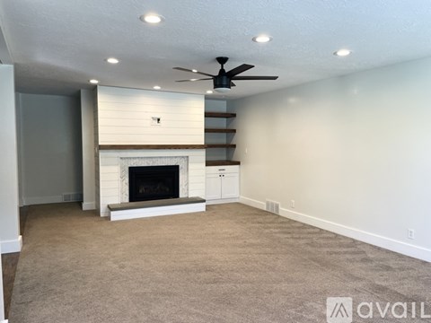 A living room with a fireplace and a carpet on the floor.
