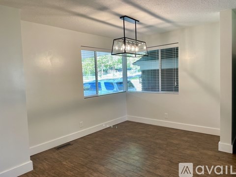 A room with a large window and a wooden floor.