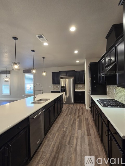 A modern kitchen with black cabinets and a white countertop.