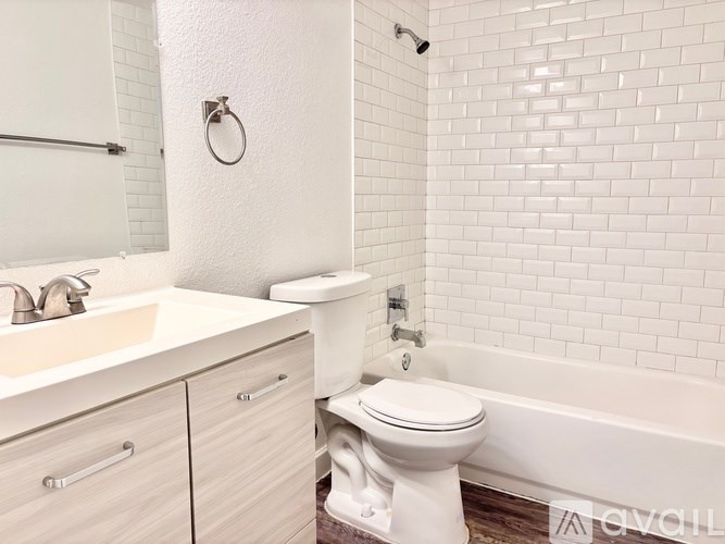 A white bathroom with a toilet, sink, and bathtub.